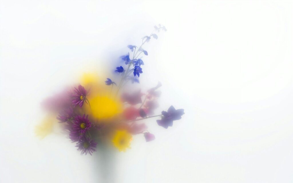 A blurred bouquet of colorful flowers against white.