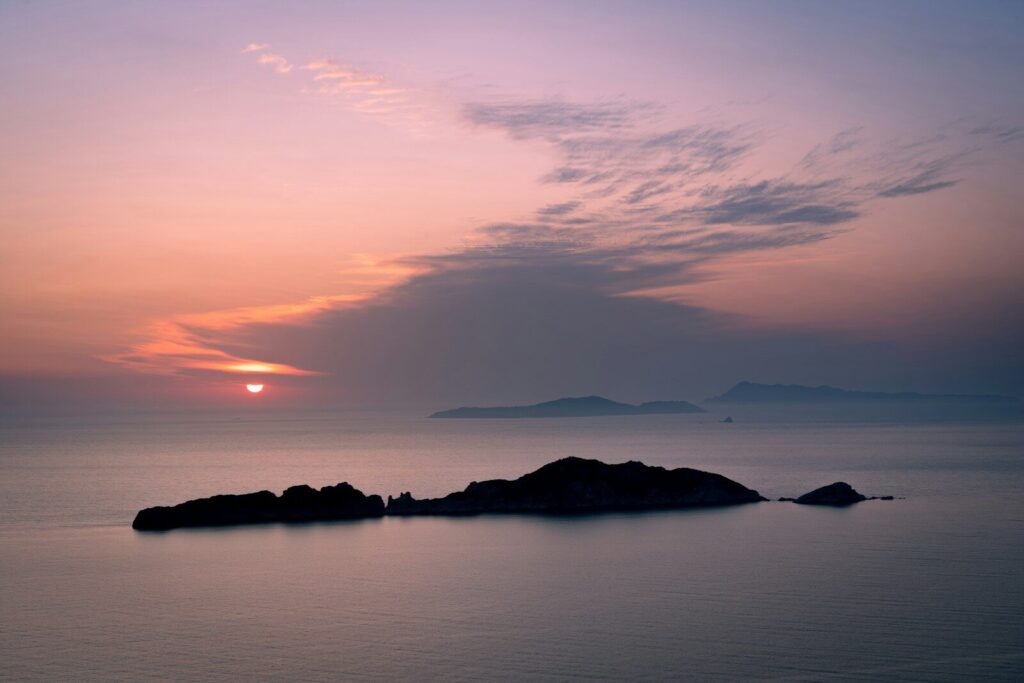 A beautiful sunset over the ocean with a small island.