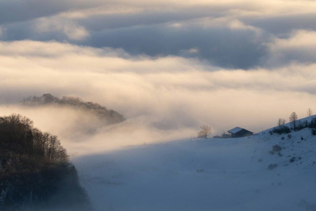 Misty mountains with a small house at sunrise